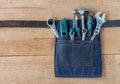 Tool belt with tools on wooden board background Royalty Free Stock Photo
