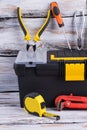 Tool box with different tools on wooden background.