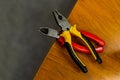 Tool home master. Pliers rubber handles on a wooden lathe two pairs