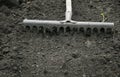 Tool garden rake smooth black dug up the ground in spring plant Royalty Free Stock Photo