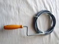 The tool for sanitary works, for a clearing of blockages of small pipes, a metal flexible wire stainless steel with the plastic Royalty Free Stock Photo