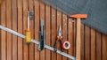 Tool set - hammer, wire cutters, centimeter, screwdriver, construction net, stationery knife on a wooden background