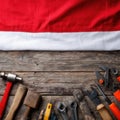 Tools arranged neatly on a wooden surface with a red and white flag in the background during a sunny day Royalty Free Stock Photo
