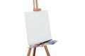 Tools of the artist. Brushes, wooden easel tripod, palette colorful. white background, studio, nobody. isolated Royalty Free Stock Photo