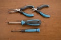 Tools, blue pliers and screwdrivers on a walnut table Royalty Free Stock Photo