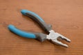 Tools, blue pliers on a walnut table Royalty Free Stock Photo