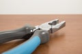 Tools, blue pliers on a walnut table Royalty Free Stock Photo