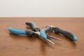 Tools, blue pliers on a walnut table Royalty Free Stock Photo