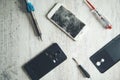 Tools with broken phones on table