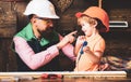 Tools construction. Father teaching little son to use carpenter tools and hammering. Father helping son at workshop. Royalty Free Stock Photo