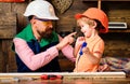 Tools construction. Father teaching little son to use carpenter tools and hammering. Father helping son at workshop. Royalty Free Stock Photo