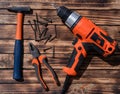 Drill, screwdriver. hammer, cutters and nails on a work desk Royalty Free Stock Photo