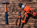 Drill, screwdriver. hammer, cutters and nails on a work desk Royalty Free Stock Photo