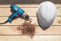 Tools for the construction of a wooden floor or terrace. Screwdriver, self-tapping screws and helmet on the wooden floor