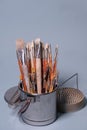 A Bunch of Rustic Artist Brushes in a Metal Bucket