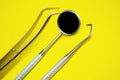 Tools for dental treatment on a yellow background