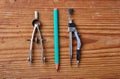 tools for drawing including metal divider, metal drawing compass and green pencil isolated on wooden background Royalty Free Stock Photo