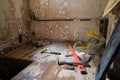 Tools on the floor of a room in a home or appartment which is being stripped for renovation