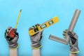 Tools in hand. Hands hold construction and carpentry tools, on a blue background. Banner, collage, construction and Royalty Free Stock Photo