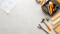 Tools including screwdriver bits and wood dowels are organized in a toolkit, accompanied by construction blueprints on a Royalty Free Stock Photo