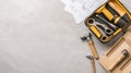 Tools including screwdriver bits and wood dowels are organized in a toolkit, accompanied by construction blueprints on a Royalty Free Stock Photo