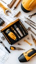 Tools including screwdriver bits and wood dowels are organized in a toolkit, accompanied by construction blueprints on a Royalty Free Stock Photo