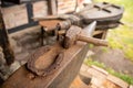 Tools in an old blacksmith& x27;s workshop. Horseshoe and hammer on a large anvil