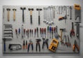 Tools organized on a metal pegboard include hammers, wrenches, screwdrivers, pliers, and saws. They Royalty Free Stock Photo