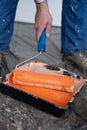 Tools for the painter and redecoration. Close-up of orange paint and roller brush in the tray. Royalty Free Stock Photo