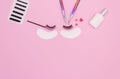 Tools and patches for eyelash extensions and artificial eyelashes on a pink background. Tools for the lashmaker. The view from the