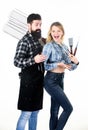 Tools for roasting meat outdoors. Picnic and barbecue. Bearded hipster and girl ready for barbecue party. Roasting and Royalty Free Stock Photo