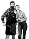 Tools for roasting meat outdoors. Picnic and barbecue. Bearded hipster and girl ready for barbecue party. Roasting and Royalty Free Stock Photo