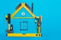 Tools in the shape of house over blue background.