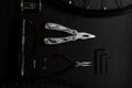 Tools on the table. spoked wheel, tire, hex keys, brake disc, multitool, pliers, flashlight, bicycle brake Royalty Free Stock Photo