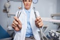 The tools to make your teeth shine. Portrait of a young woman holding teeth cleaning tools in her dentists office. Royalty Free Stock Photo