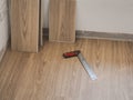 tools and Vinyl flooring is placed on the floor under construction as part of the interior work with artificial wood flooring Royalty Free Stock Photo