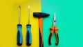 Tools worker, hammer, screwdrivers, pliers on bright yellow and blue background