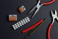 Tools for working with electricity, terminal blocks and heat shrink tubes lie on a dark background Royalty Free Stock Photo