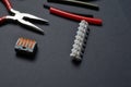 Tools for working with electricity, terminal blocks and heat shrink tubes lie on a dark background Royalty Free Stock Photo