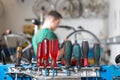Tools in a workshop with bicycle mechanic repairing a wheel in background Royalty Free Stock Photo