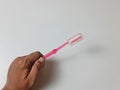 Tootbrush wuth pink color with hand and grey background