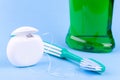 Tooth care and oral hygiene products. Dental floss, toothbrush and mouthwash on blue background Royalty Free Stock Photo