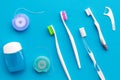 Tooth care with toothbrush, dental floss and dentist instruments. Set of cleaning products for teeth on blue background Royalty Free Stock Photo