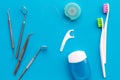 Tooth care with toothbrush, dental floss and dentist instruments. Set of cleaning products for teeth on blue background Royalty Free Stock Photo