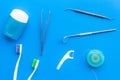 Tooth care with toothbrush, dental floss and dentist instruments. Set of cleaning products for teeth on blue background Royalty Free Stock Photo