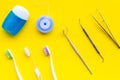 Tooth care with toothbrush, dental floss and dentist instruments. Set of cleaning products for teeth on yellow Royalty Free Stock Photo