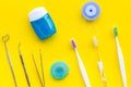 Tooth care with toothbrush, dental floss and dentist instruments. Set of cleaning products for teeth on yellow Royalty Free Stock Photo