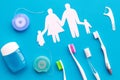 Tooth care with toothbrush, dental floss and family figures. Set of cleaning products for teeth on blue background top Royalty Free Stock Photo