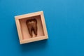 Tooth from chocolate in box on blue paper background. Top view. Copy space. Healthy teeth or dental care concept Royalty Free Stock Photo