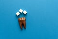 Tooth from chocolate with sugar on blue paper background. Top view. Copy space. Healthy teeth or dental care concept Royalty Free Stock Photo